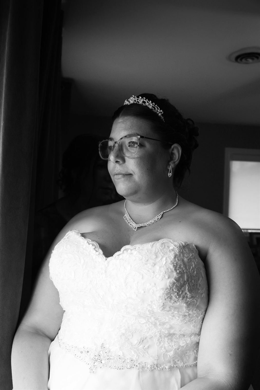Black and white portrait of a bride by a window