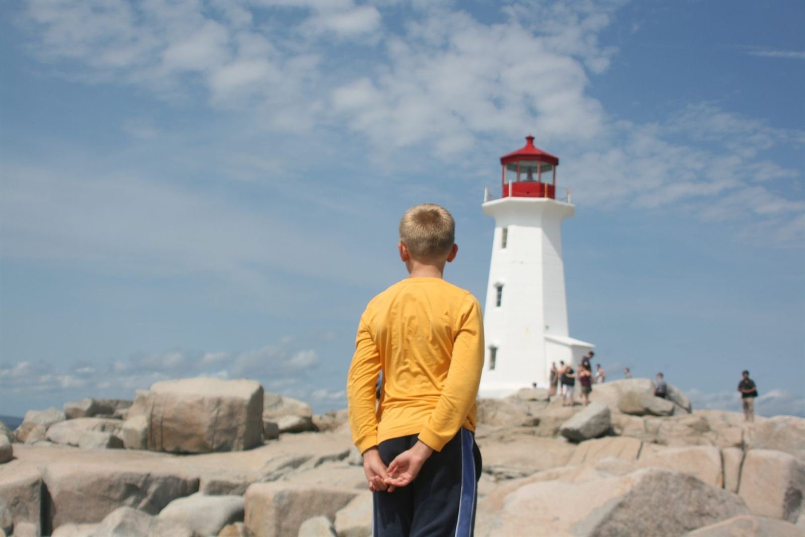 A boy in yellow looking at a lighthouse