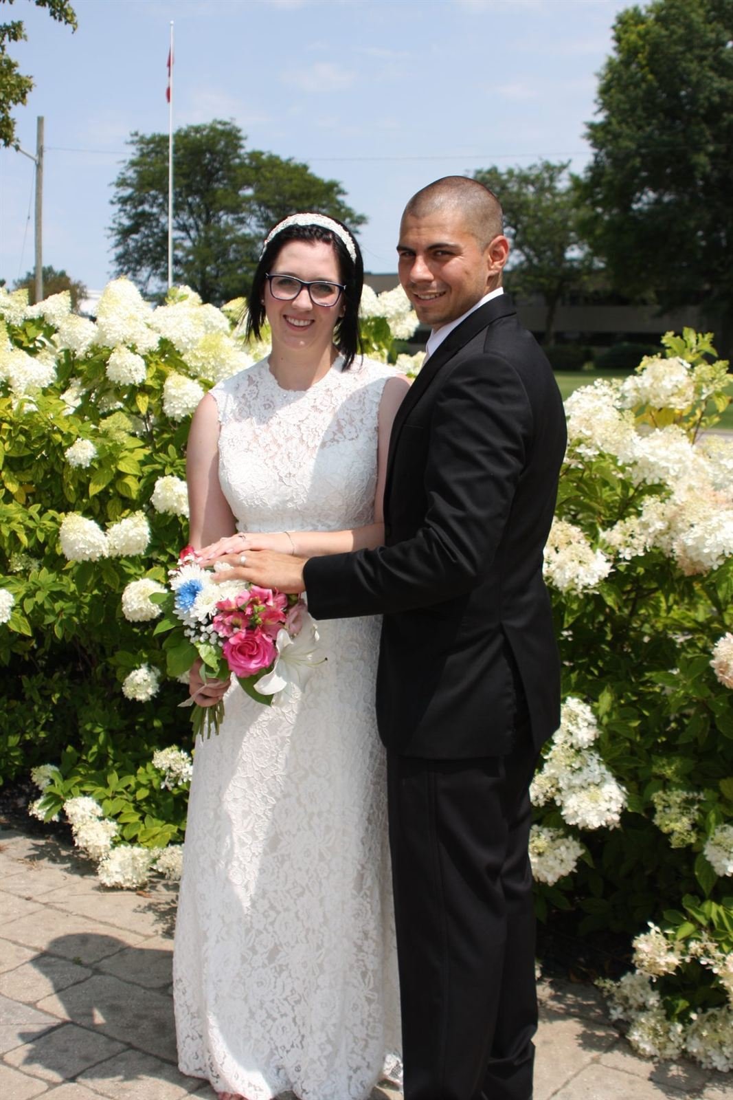 In bloom — bride and groom by white hydrangeas