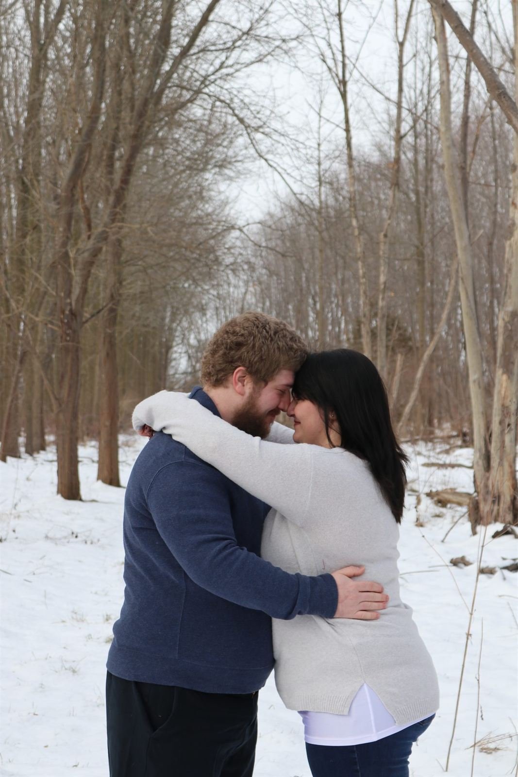 First snow — couple hugging in a snowy forest