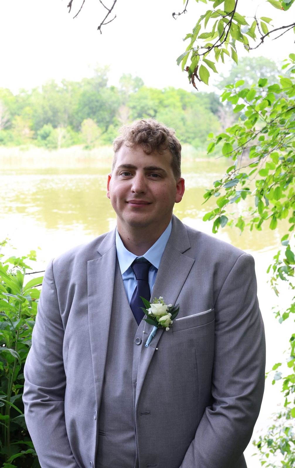 The groom — groom in a grey suit by the water