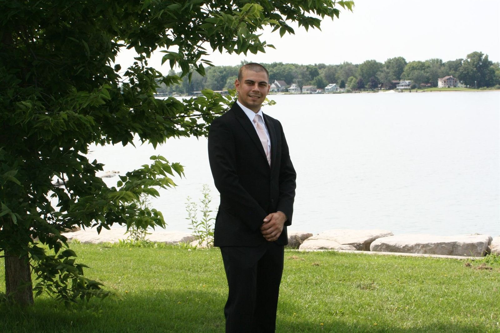 Waiting by the lake — groom under a tree by the water