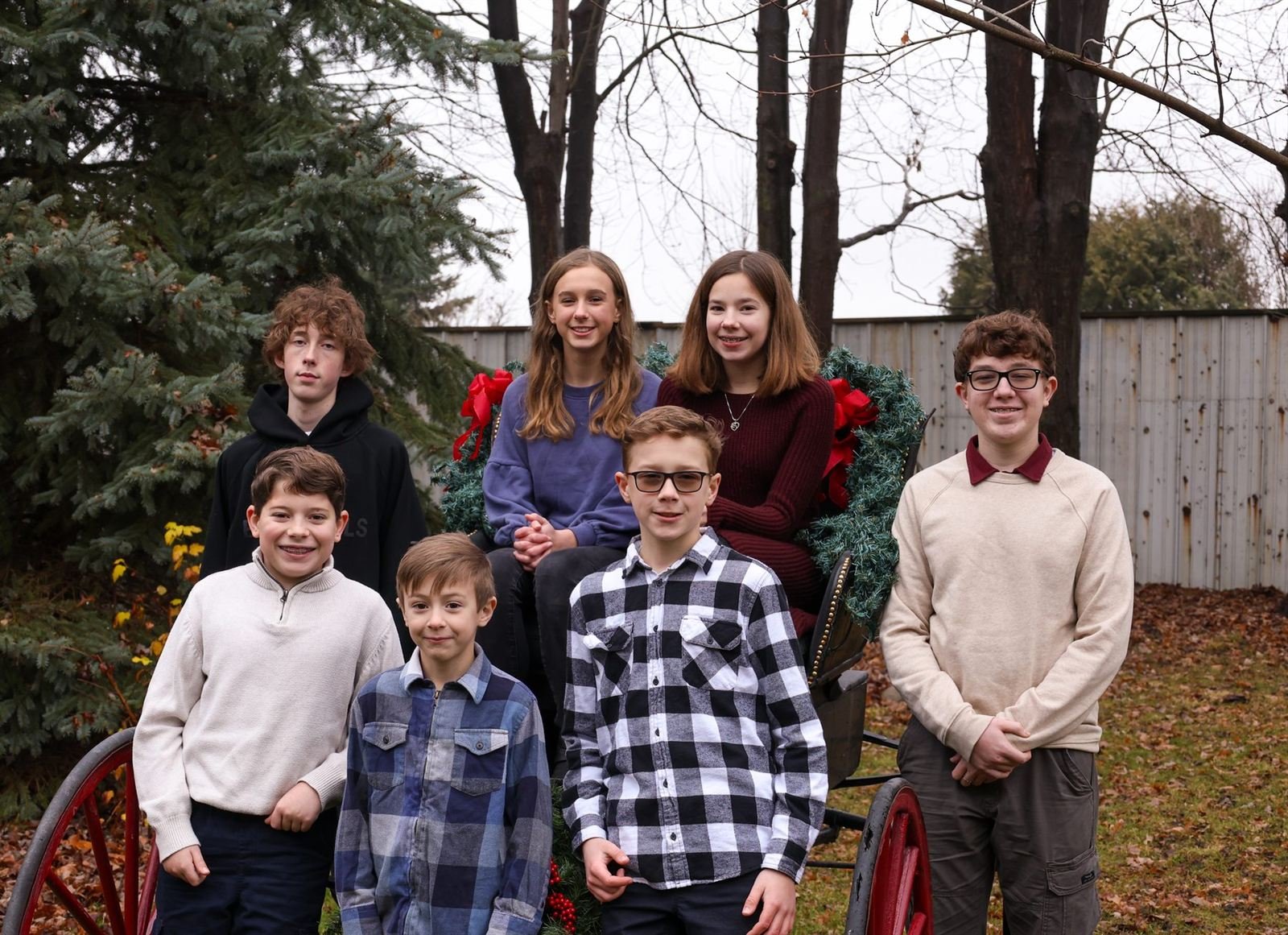 The whole crew — group of kids by a holiday carriage