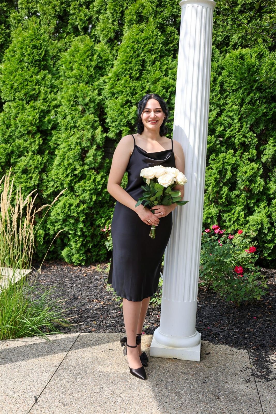 Cedar and column — woman with roses beside a white column